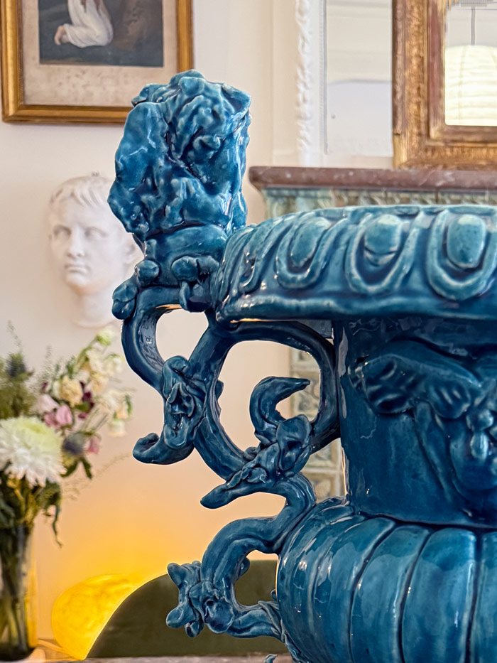 Détail d’un vase décoratif bleu de Gérald Schmite, en céramique dans un intérieur haussmannien avec buste classique en arrière-plan, vendu à la galerie Vermeulen.