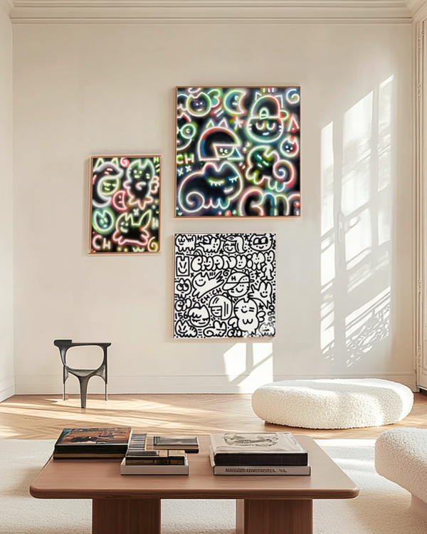Accrochage de peintures l'artiste franco-colombien CHANOIR, dans un intérieur parisien. Trois oeuvres street art sont accrochés au mur d'un salon minimaliste.