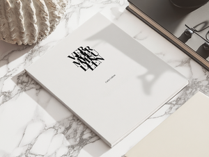Carte cadeau Galerie Vermeulen posée sur un bureau en marbre, avec une mise en scène élégante et minimaliste – une invitation à offrir de l’art contemporain avec style.