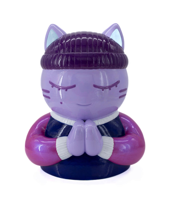 Sculpture "Charité" par CHANOIR – œuvre originale. Chat mauve aux yeux clos, coiffé d’un bonnet violet foncé, vêtu d’un t-shirt bleu marine et aux manches rose métallisé. Pièce unique peinte à la main, alliant street art et art contemporain.