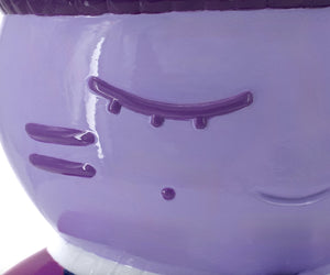 Gros plan sur la sculpture "Charité" par CHANOIR – œuvre originale. Détail du visage mauve aux yeux clos, mettant en avant la texture peinte à la main et les nuances uniques de l’artiste. Fusion de street art et sculpture contemporaine.
