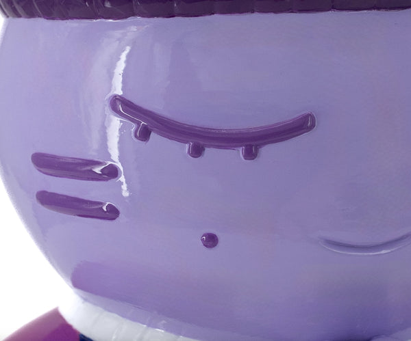 Gros plan sur la sculpture "Charité" par CHANOIR – œuvre originale. Détail du visage mauve aux yeux clos, mettant en avant la texture peinte à la main et les nuances uniques de l’artiste. Fusion de street art et sculpture contemporaine.