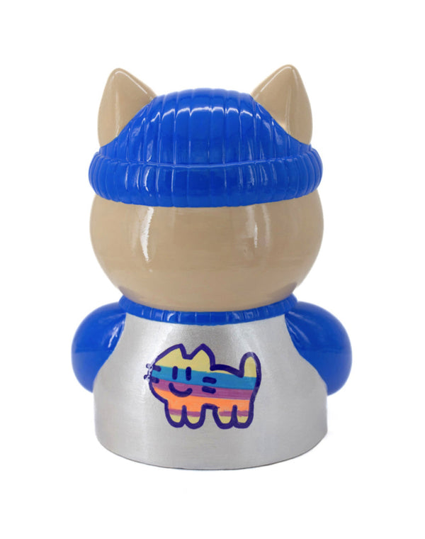 Dos d'une sculpture CHANOIR, coiffé d’un bonnet bleu vif, vêtu d’un maillot blanc nacré avec manches bleu vif et orné d’un motif de chat à rayures colorées sur le dos. Pièce unique peinte à la main, fusion de street art et art contemporain.
