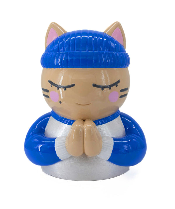 Sculpture "Foi" par CHANOIR – œuvre originale. Chat beige aux yeux clos, coiffé d’un bonnet bleu vif et vêtu d’un maillot blanc nacré avec manches bleu vif et bordures blanches. Pièce unique peinte à la main, fusion de street art et sculpture contemporaine.