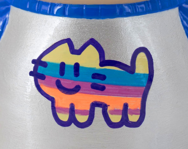 Gros plan sur la sculpture "Foi" par CHANOIR – œuvre originale. Détail du dos bleu vif et blanc nacré, mettant en avant un logo de chat multicolor peint à la main par l’artiste. Fusion de street art et sculpture contemporaine.
