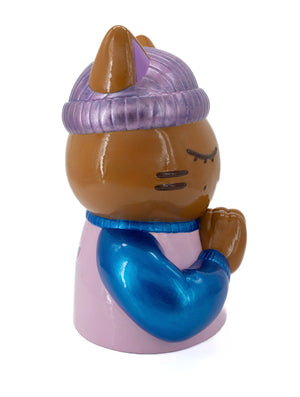 Vue de profil droit de la sculpture "Justice" par CHANOIR – Œuvre originale. Chat méditatif aux yeux clos, portant un bonnet violet et un pull rose avec des manches bleu métallisé. Peinte à la main, chaque pièce est unique, entre street art et design contemporain.