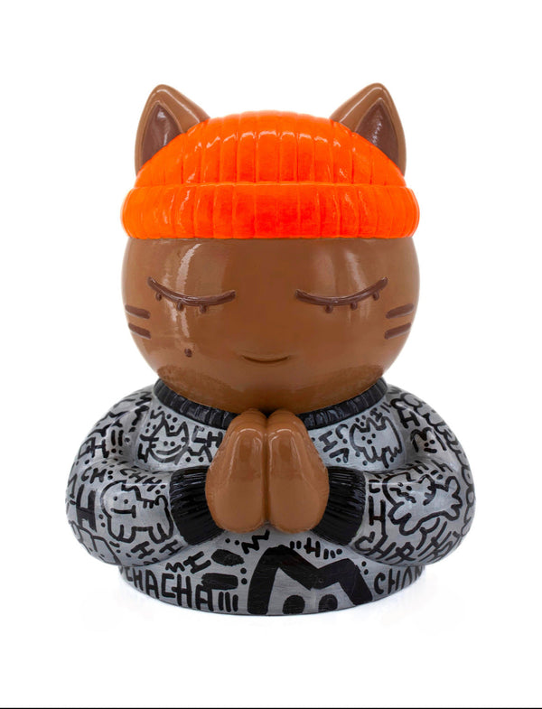 Vue de face de la sculpture collector de CHANOIR, ce chat méditatif porte un tee-shirt gris métallisé avec des graffiti noirs, il est coiffé d'un bonnet orange fluo. Une oeuvre d'art contemporain mêlant pop art, art urbain et figuration libre.