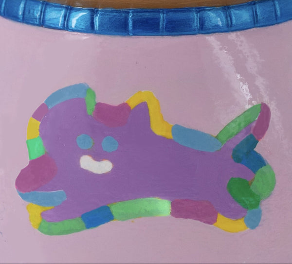 Détail d’une sculpture CHANOIR peinte à la main, mettant en avant un chat stylisé multicolore sur une surface rose laquée. Lignes fluides et couleurs vives caractéristiques du style street art de l’artiste.