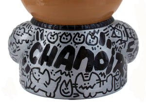 Détail de la sculpture "Prudence" par CHANOIR, montrant des graffiti noirs de chats stylisés sur fond argenté, avec la signature de l’artiste.