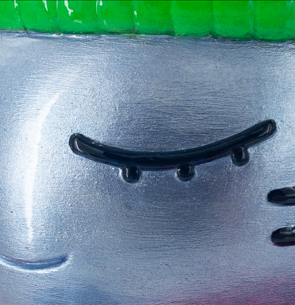 Détail de l'oeil fermé gauche de l’épreuve d’artiste CHANOIR – Sculpture unique peinte à la main. Chat bleu métallisé, coiffé d’un bonnet vert vif. Pièce exclusive fusionnant street art, Figuration libre et art contemporain.