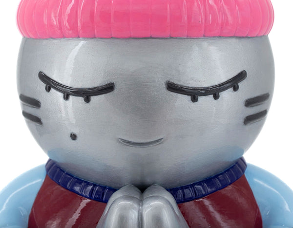 Gros plan sur la sculpture "Espérance" par CHANOIR – œuvre originale. Détail du visage argenté aux yeux clos, bonnet rose et mains jointes en prière. Pièce unique peinte à la main, fusion de street art et de sculpture contemporaine.