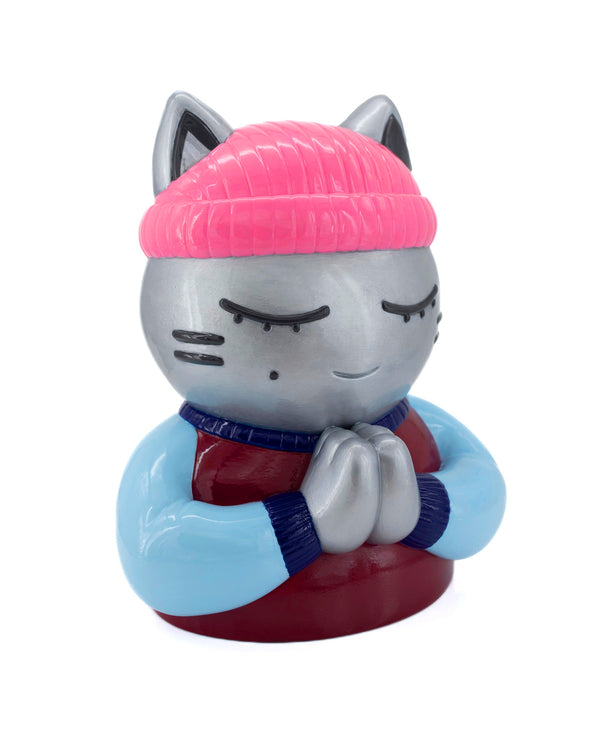 Vue trois-quarts droit de la sculpture contemporaine street-art "Espérance" par l'artiste CHANOIR – œuvre originale. Chat gris métallique aux yeux clos, coiffé d’un bonnet rose fluo et vêtu d’un t-shirt bordeaux avec manches bleu clair. Pièce unique peinte à la main puis vernie.